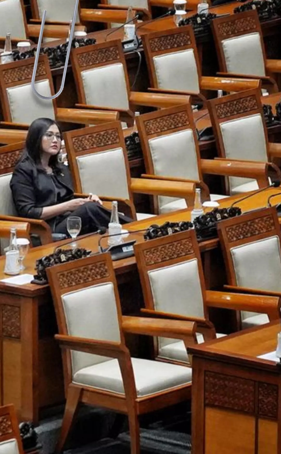 Anggota DPR duduk dikelilingi kursi kosong 